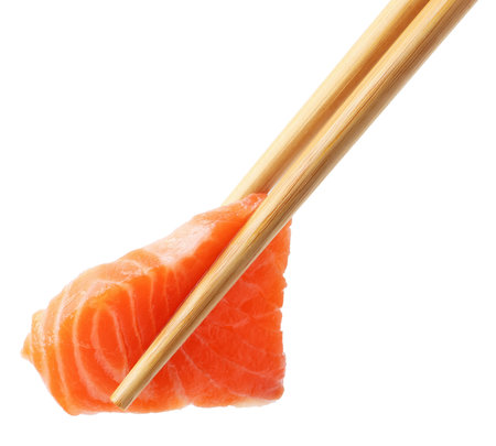 Chopsticks with fresh salmon sashimi isolated on whiteの写真素材