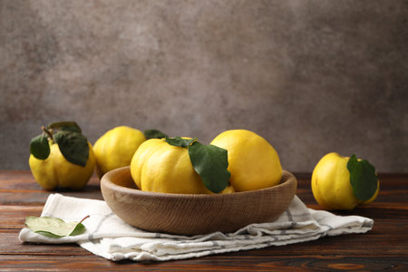 Fresh ripe quinces with leaves on wooden tableの写真素材