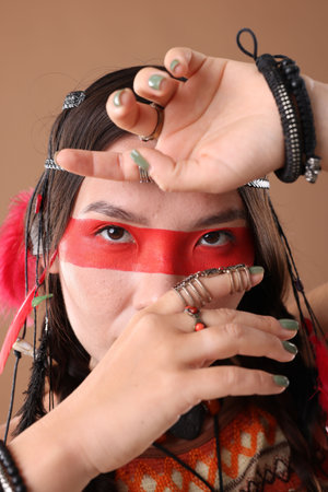 Shaman woman with face painting on pale brown background