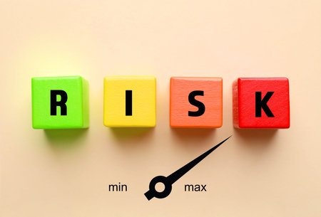 Risk word made of wooden cubes on beige background, top view. Arrow maximum indicating level of risk