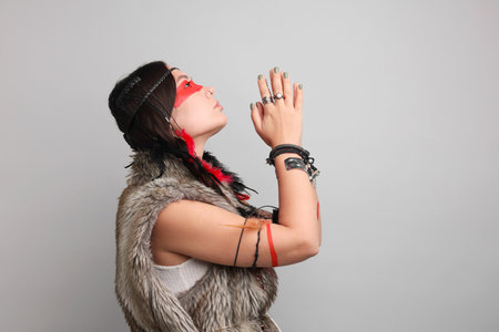 Shaman woman with face painting on light gray background, space for textの写真素材