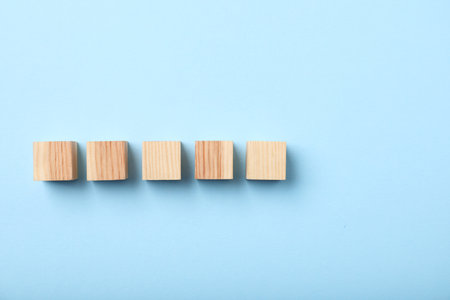 Wooden cubes on light blue background, top viewの写真素材