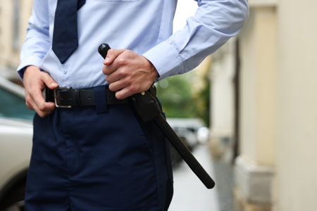 Police officer with baton on city street, closeupの写真素材