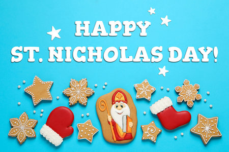Happy St. Nicholas Day greeting card design with gingerbread cookies on light blue background, top viewの写真素材
