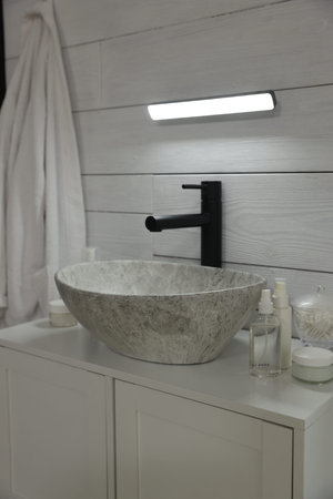 Portable LED light on wall over sink in bathroomの写真素材