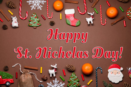 Happy St. Nicholas Day greeting card design with sweet treats and festive decor on brown background, top viewの写真素材
