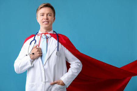 Doctor wearing superhero cape on light blue background. Space for textの写真素材
