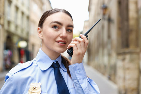 Police officer talking via radio on city streetの写真素材