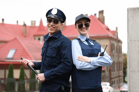 Portrait of smiling police officers on city streetの写真素材