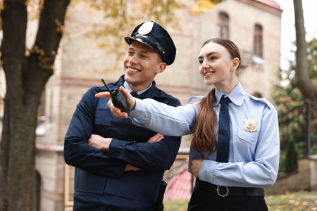 Police officer showing her colleague something on city streetの写真素材