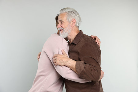 Father and son hugging on light gray backgroundの写真素材