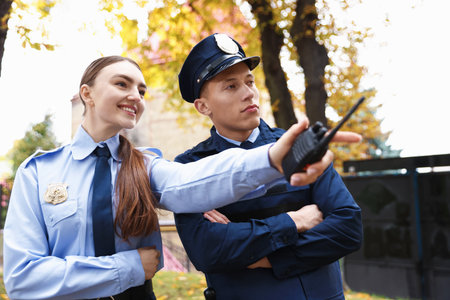 Police officer showing her colleague something on city streetの写真素材