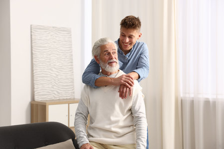 Happy son hugging his father at homeの写真素材