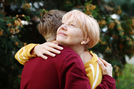 Mother and son hugging outdoors. Family bonding