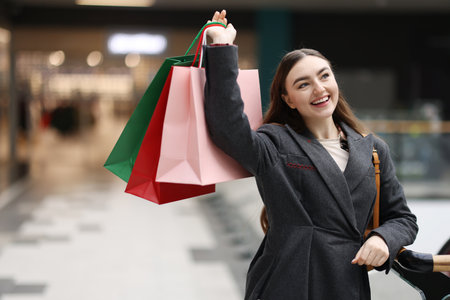 Woman with different shopping bags in mall, space for textの写真素材
