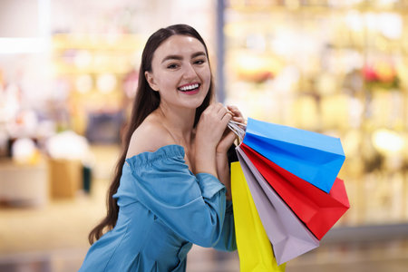 Woman with different shopping bags in mall