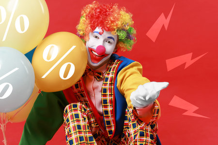 Clown holding balloons on red background