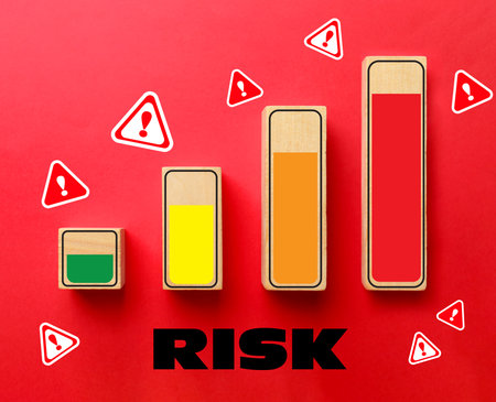 Wooden figures with different colors indicating level of risk and warning signs on red background, top viewの写真素材