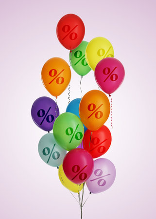 Colorful balloons with percent signs on pink backgroundの写真素材