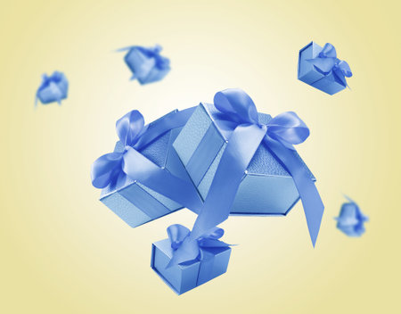 Gift boxes flying in air on beige gradient backgroundの写真素材