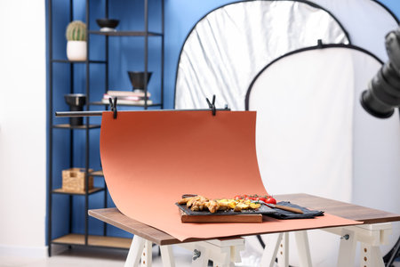 Shooting chicken wings, potato wedges, spices and tomatoes with camera in studio. Professional food photographyの写真素材