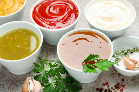 Different sauces, spices and herbs on light table, closeupの写真素材