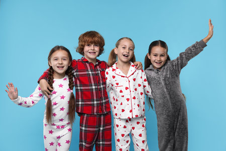 Cute children in pajamas on light blue backgroundの写真素材