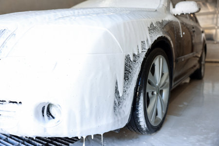 Auto covered with cleaning foam at car wash, closeupの写真素材