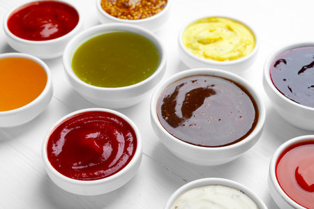Different sauces in bowls on white wooden table, closeupの写真素材