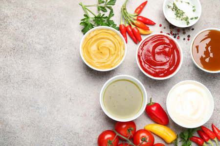 Different sauces, spices and herbs on light table, flat lay. Space for textの写真素材