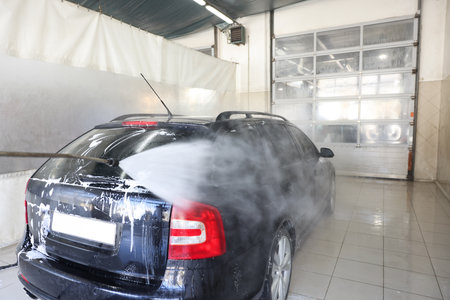 Washing auto with high pressure water jet at car wash, closeupの写真素材