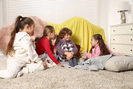 Cute children in pajamas on floor at homeの写真素材