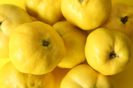 Fresh quince fruits on yellow background, closeupの写真素材