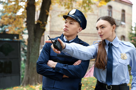 Police officer showing her colleague something on city streetの写真素材