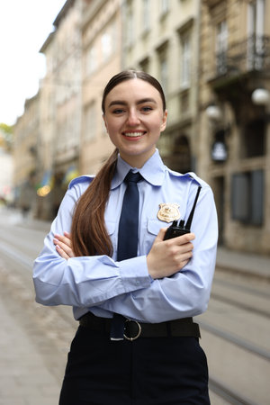 Police officer with radio on city streetの写真素材