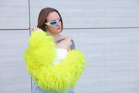 Young woman with piercings, tattoos and stylish clothes outdoors, space for textの写真素材