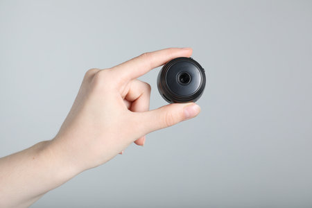 Woman with hidden spy camera on light gray background, closeupの写真素材