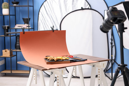 Shooting chicken wings, potato wedges, spices and tomatoes with camera in studio. Professional food photographyの写真素材