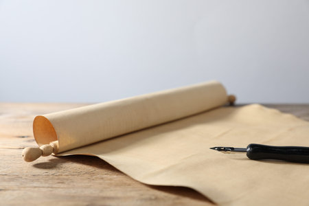 Old paper scroll and fountain pen on wooden table, closeupの写真素材
