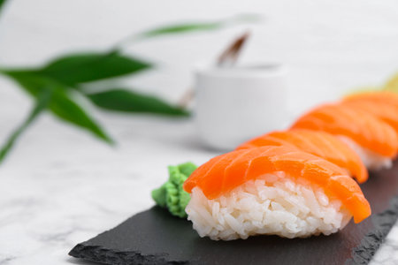 Delicious nigiri sushi with salmon and wasabi on white marble table, closeup. Space for textの写真素材