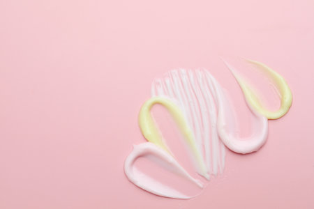 Samples of different cosmetic products on pink background, flat lay. Space for textの写真素材