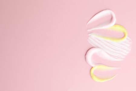 Samples of different cosmetic products on pink background, flat lay. Space for textの写真素材