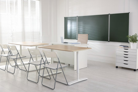 Green chalkboard and stylish furniture in classroom. Mockup for designの写真素材