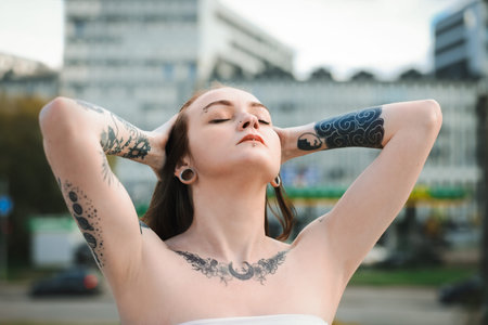 Young woman with piercings and tattoos outdoorsの写真素材