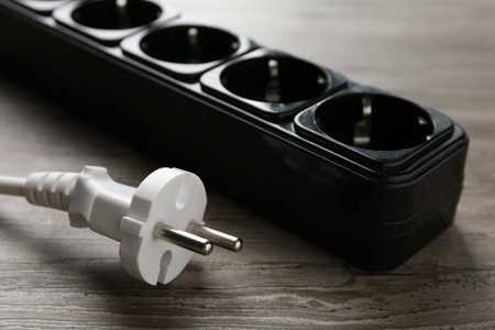 Power strip with electrical plug on wooden table, closeupの写真素材