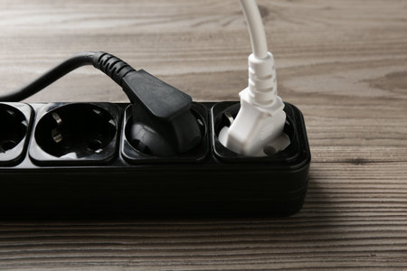 Power strip with electrical plug on wooden table, closeupの写真素材