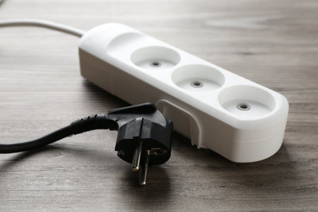 Power strip with electrical plug on wooden table, closeupの写真素材