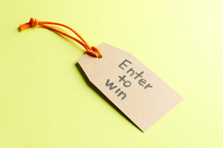 Tag with phrase Enter To Win on yellow background, closeupの写真素材