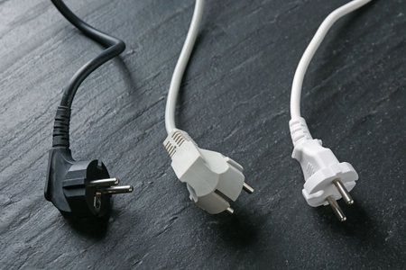Electrical wires with plugs on black table, closeupの写真素材