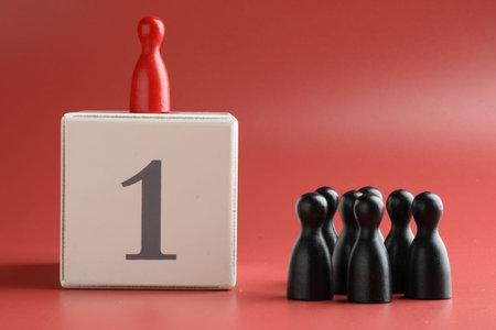 Winner. Human figures, red one on top of cube with number 1 against color backgroundの写真素材